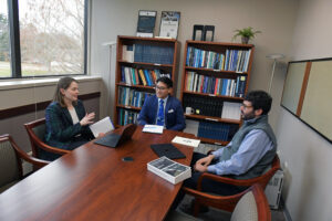 Legal program staff and Law Fellows converse at a conference table