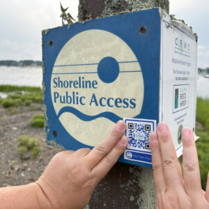 A QR code sticker is affixed to a shoreline public access sign