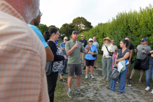 Nate Merrill of the EPA talks into a microphone in front of a crowd at Barrington Beach