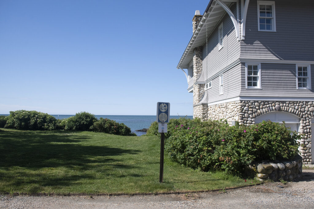 Shoreline right-of-way sign marks path adjacent to waterfront home