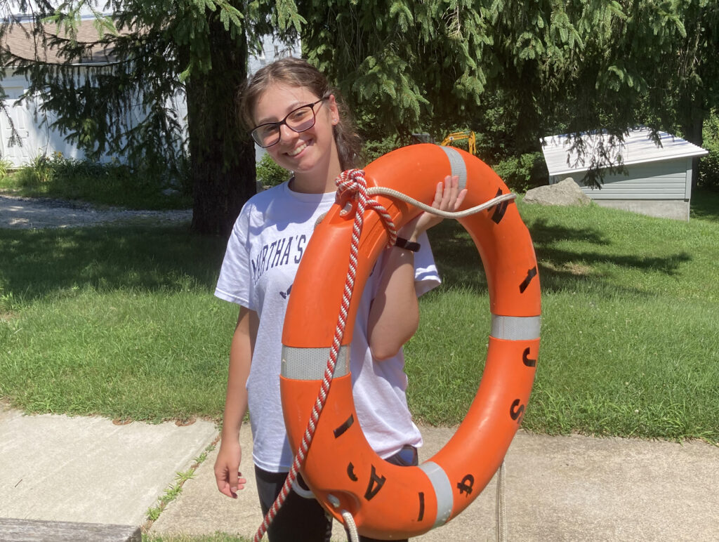 Community Engaged Intern Corinne DeAngelis holds a life ring at the URI East Farm campus