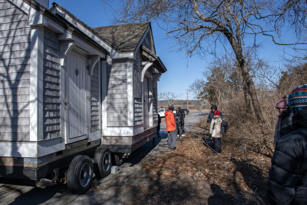 Students inspect the beach house structure that is moved from Mackeral Cove Beach each fall. It contains the facilities for beach visitors.