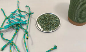 Samples of nets, plastic line, and plastic pellets are arrayed on a table