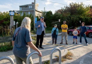 State Sen. Mark McKenney speaks to a group of walk participants in front of a shoreline right-of-way sign