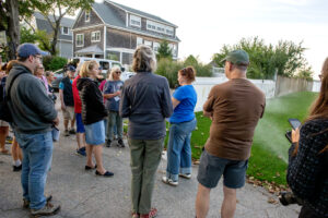 CRMC's Laura Dwyer speaks to walk particpants in front of a right-of-way with active sprinklers