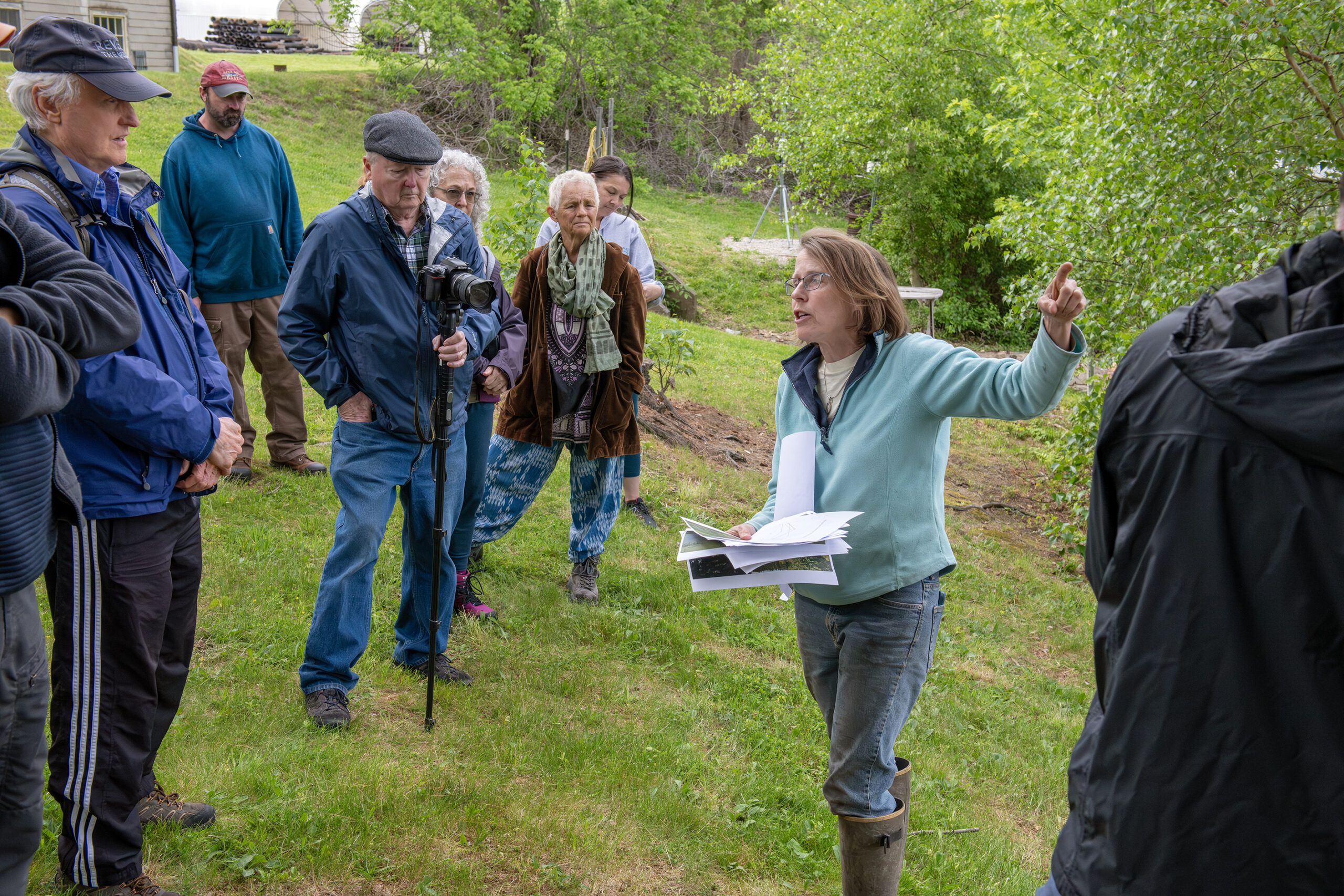 Wenley Ferguson stannds on the bank of the Kickemuit River talking to a group