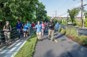 A group walks along a bike shaded bike path and sidewalk
